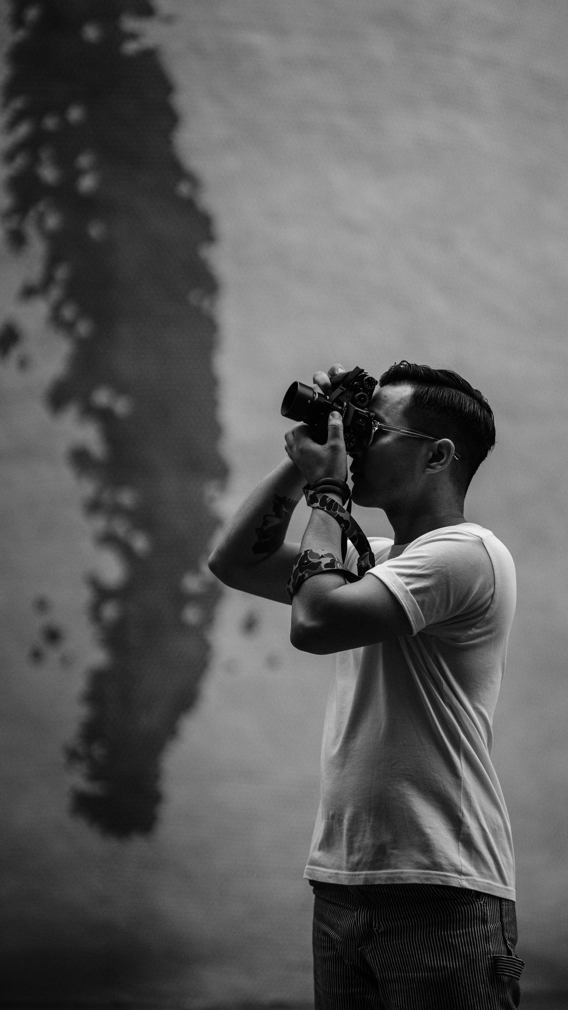 Grayscale Photo of Man Taking Pictures Using a Camera
